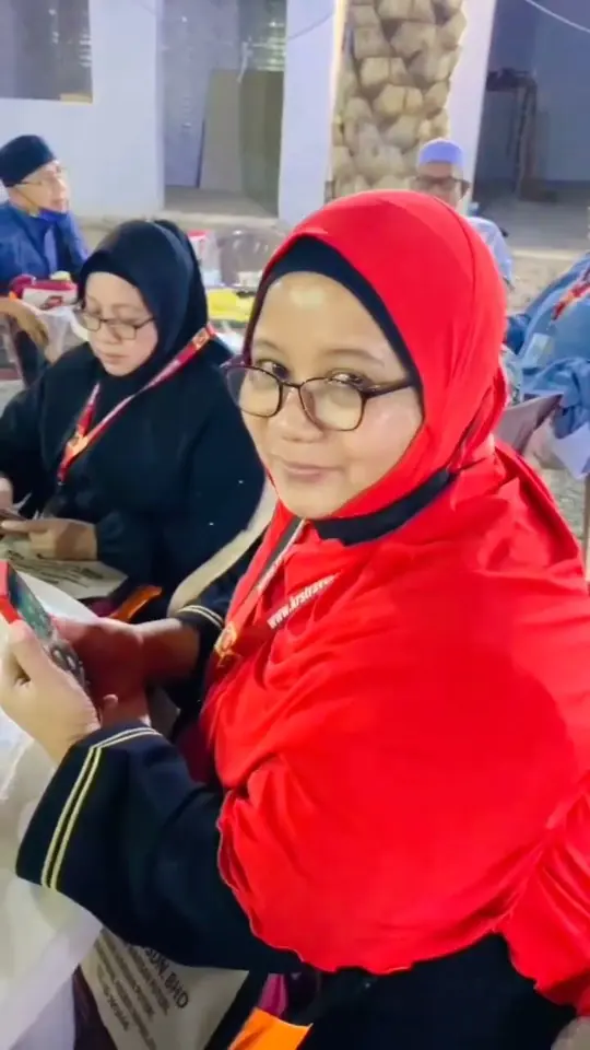 Jemaah wanita bertudung merah di kalangan jemaah lain yang sedang duduk