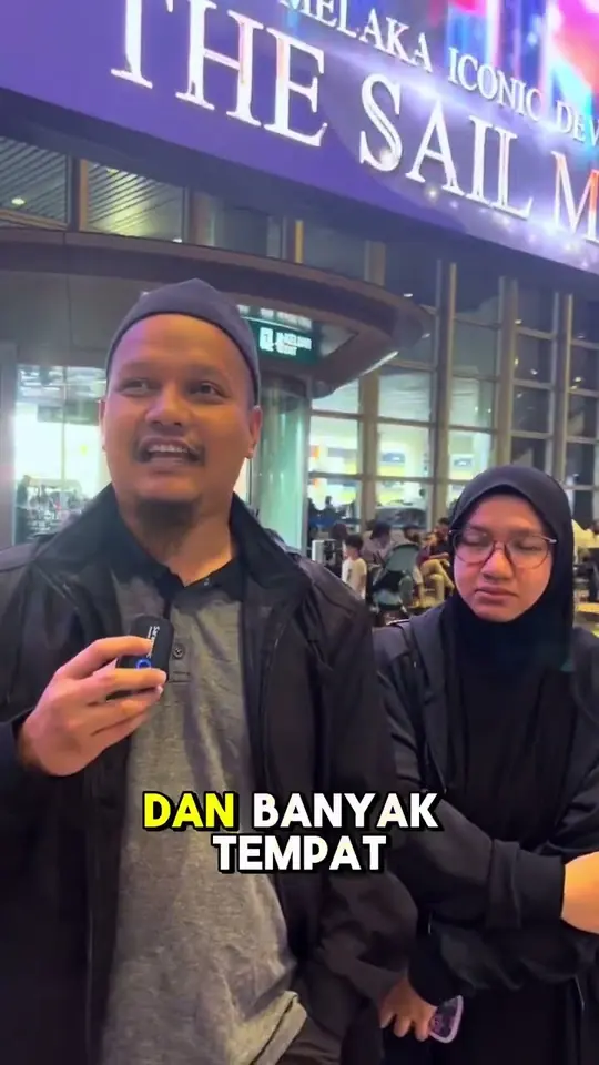 Sepasang jemaah memberi testimoni di hadapan bangunan The Sail, Melaka