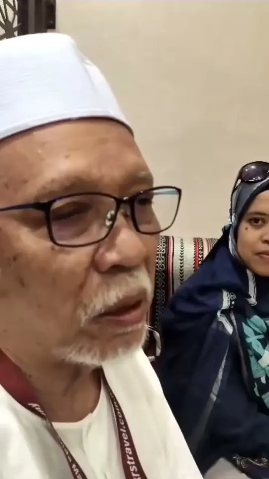 Jemaah lelaki berusia berkopiah putih bercakap rapat ke kamera