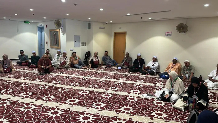 Jemaah haji KRS Travel duduk bersila mengikuti sesi taklimat di dewan penginapan pada musim haji 1446H