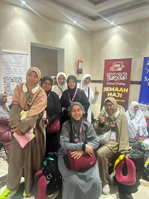 Jemaah haji KRS Travel bersama bagasi di ruang ketibaan, di hadapan sepanduk Ahlan wa Sahlan Jemaah Haji KRS Travel