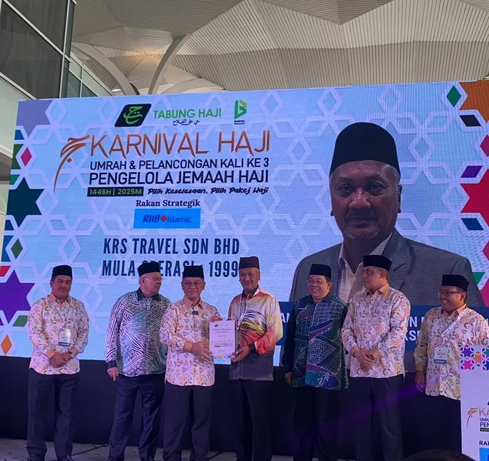 Majlis penyampaian penghargaan di pentas Karnival Haji 1446H, skrin memaparkan KRS Travel Sdn Bhd mula beroperasi sejak 1999