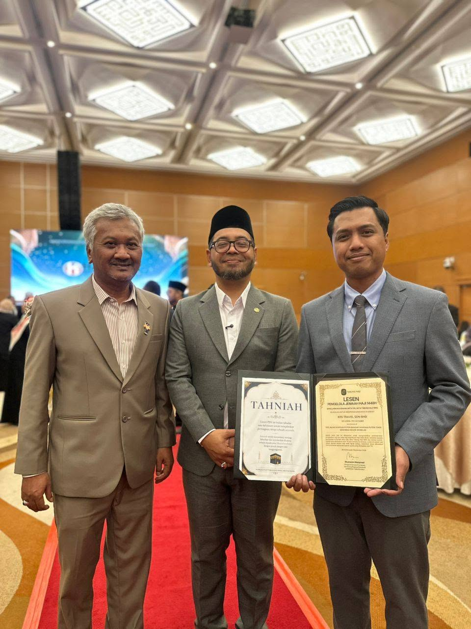 Tiga peserta majlis bergambar bersama sijil Lesen PJH 1448H KRS Travel